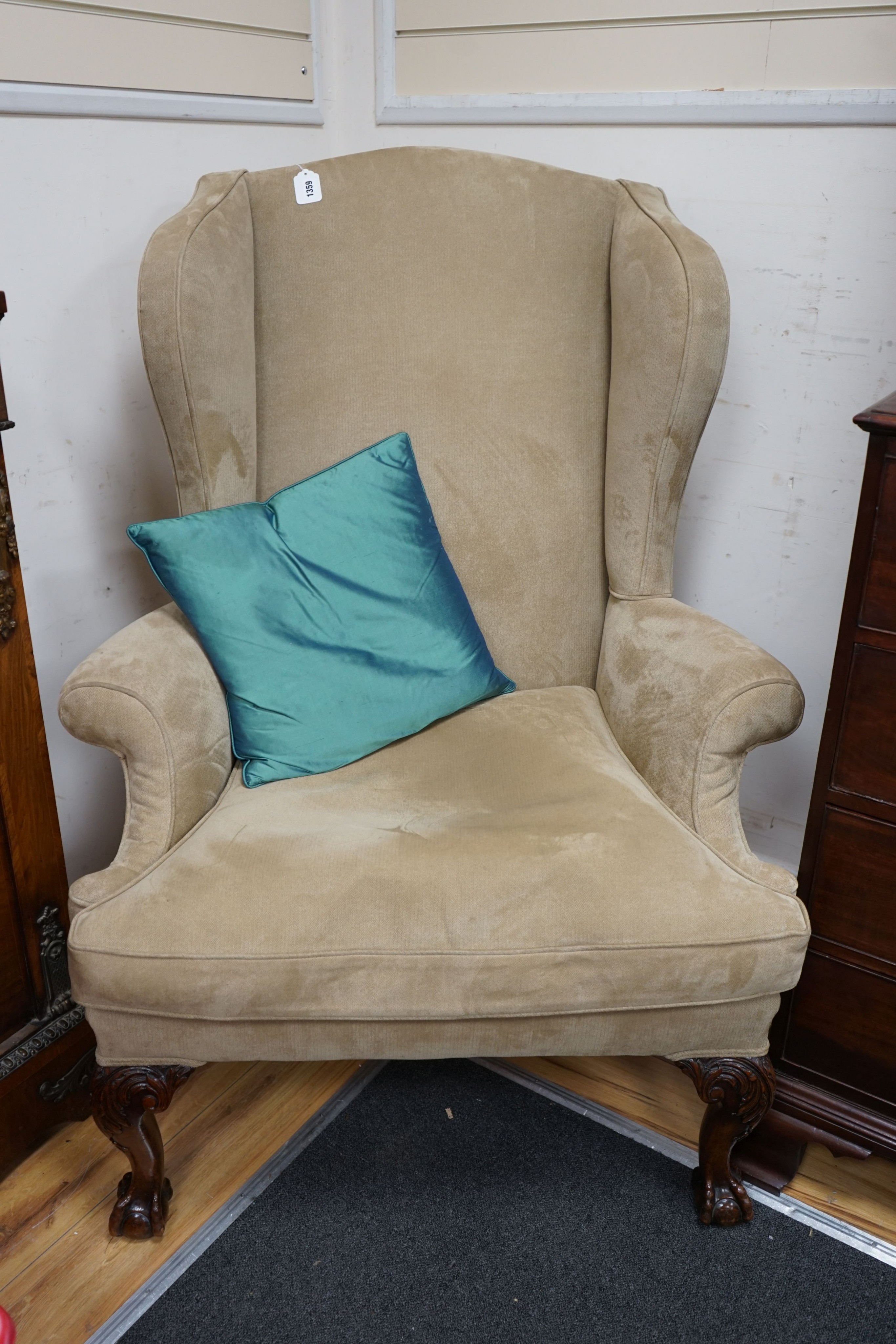 A heavy large upholstered wing armchair, width 92cm, depth 90cm, height 126cm